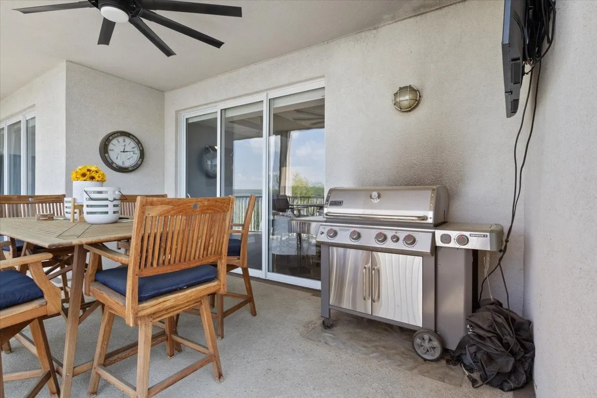 An exterior scene highlighting a grill and dining table adorned with flowers, creating an inviting setting for outdoor cooking, dining, and socializing. The mood is casual and welcoming, ideal for barbecues and gatherings.