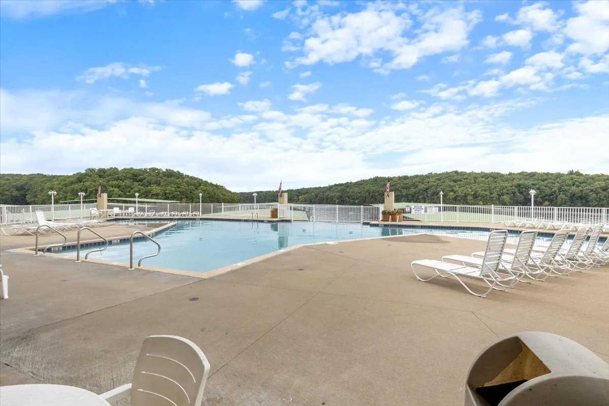 This exterior shot highlights a serene swimming pool bordered by comfortable lounge chairs and surrounded by a beautifully landscaped area. The atmosphere is leisurely, evoking visions of guests enjoying sunset swims or relaxing afternoons regardless of season.